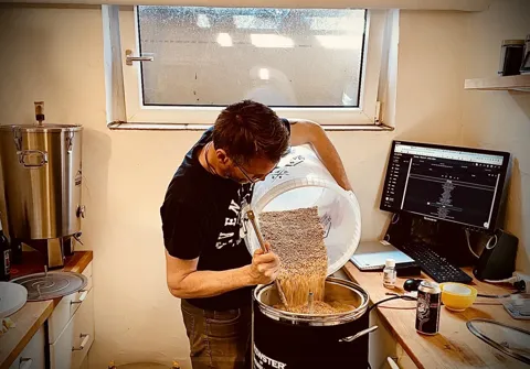 Lars Jørgensen hælder malt i brygkedlen